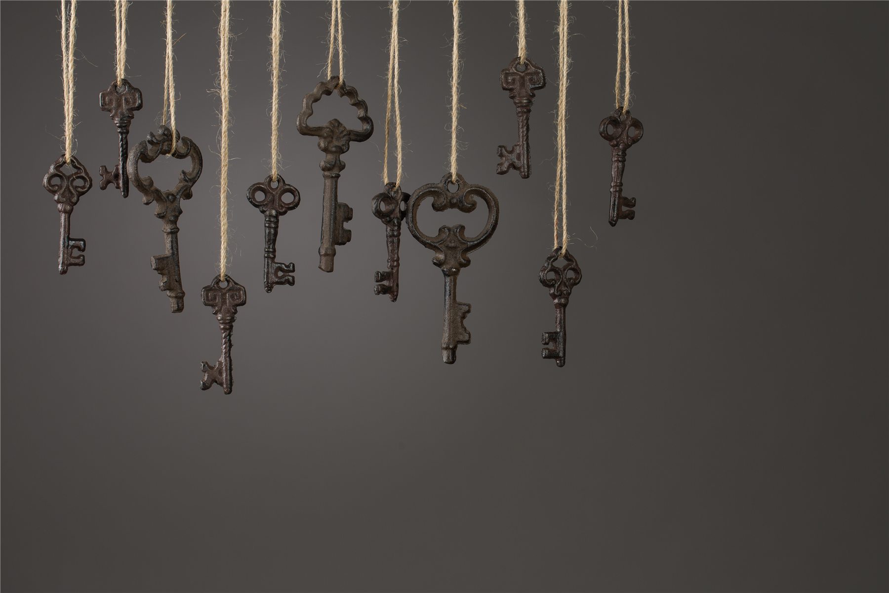 Clés anciennes en laiton suspendues sur fond sombre, atelier de serrurerie à Oullins
